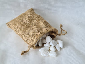 Decorative white stones in a drawstring gunny bag.